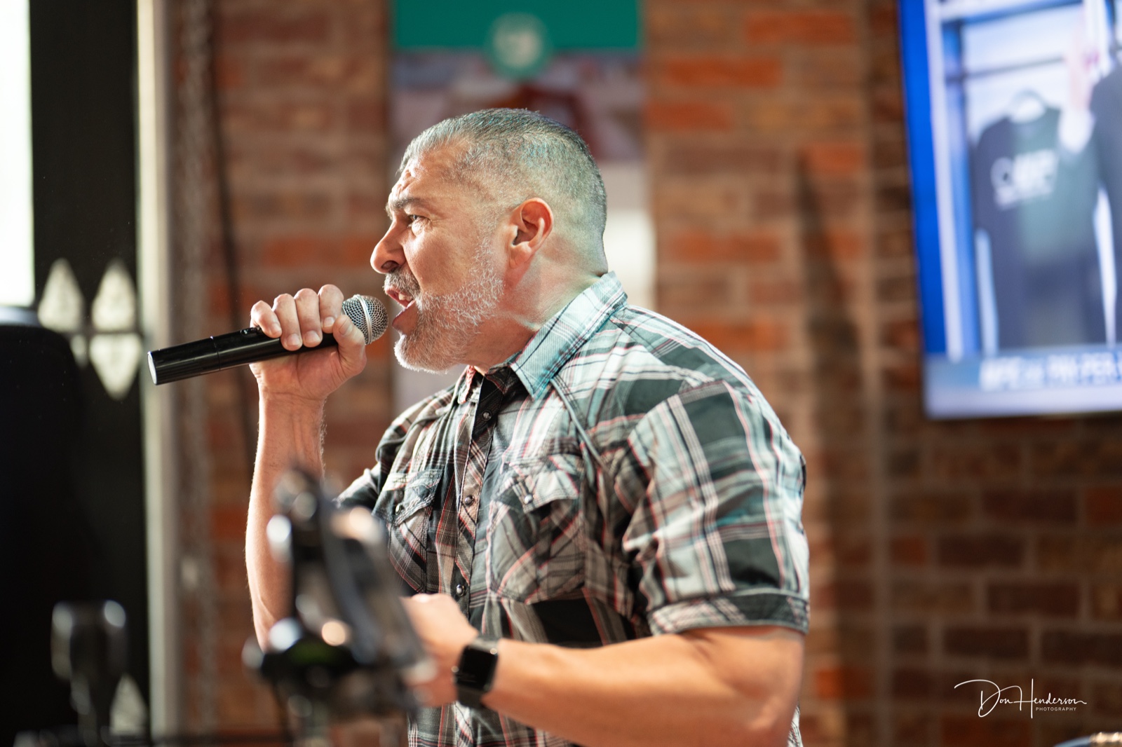 Jay Tapia speaking into a microphone at an event